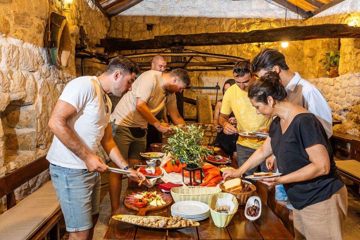 Gosti se poslužuju domaćim delicijama za drvenim stolom u mlinici