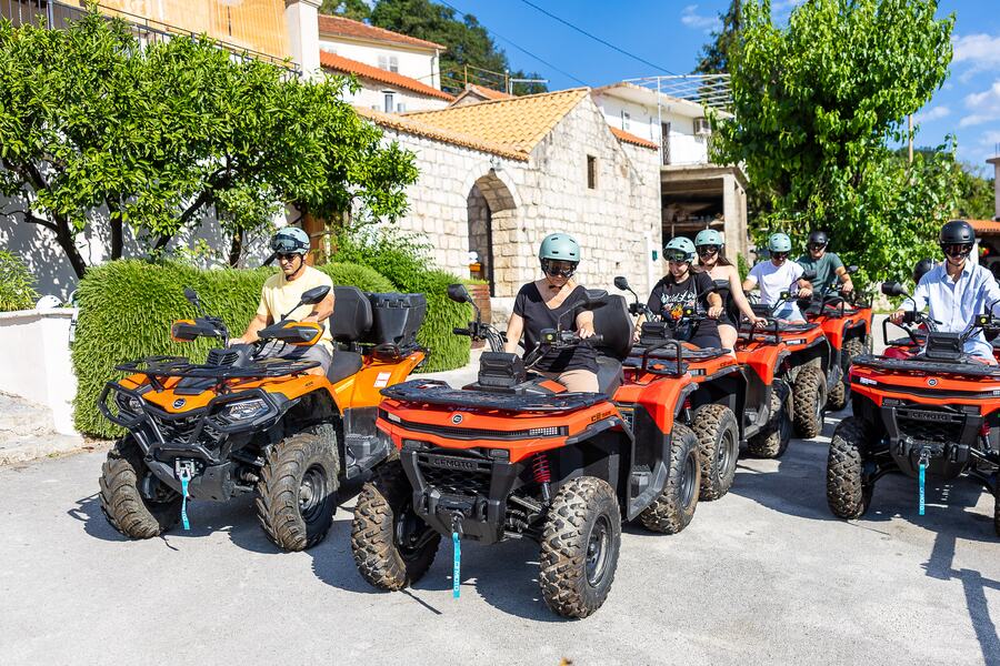 Kolona quadova prolazi kroz selo uz kamenu kuću